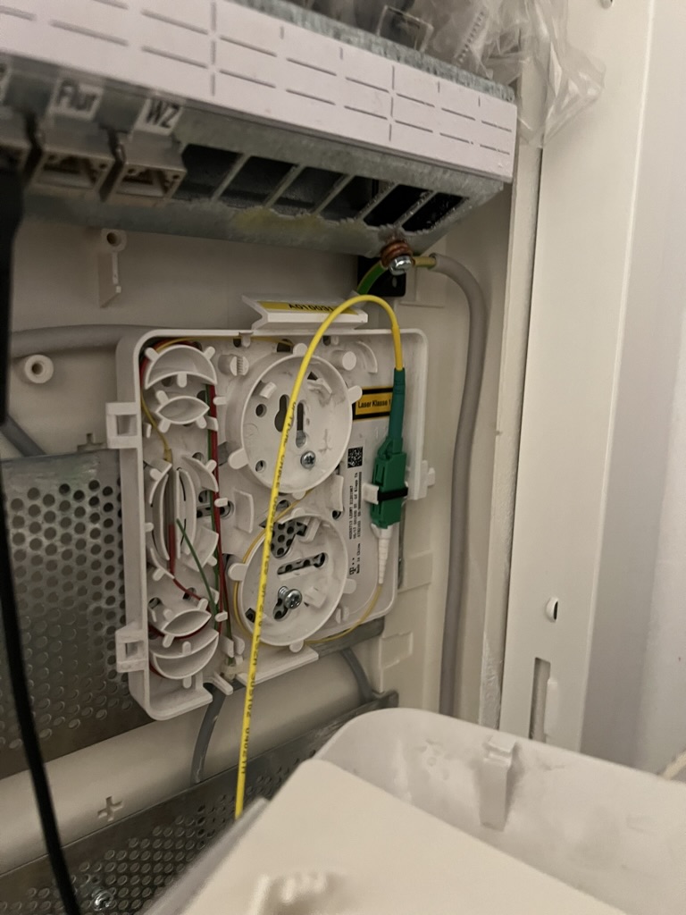 The fiber optic termination box; white plug: fiber from the house; green plug: fiber to the modem.